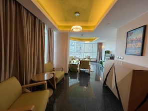 En hotellobby med en sittgrupp, en receptionsdisk och utsikt över stadsbilden.