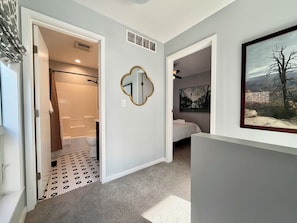 A hallway with a bathroom, a bedroom, and a living area. - Walkable downtown Dayton MCM townhome with garage and balcony! (Dayton)