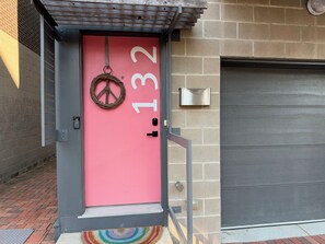 A pink door with the number 132, a metal mailbox, and a metal gate. - Walkable downtown Dayton MCM townhome with garage and balcony! (Dayton)