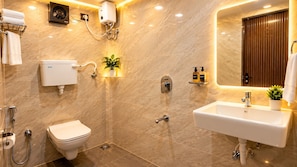 Une salle de bain moderne équipée de toilettes, d’un lavabo, d’une douche et d’un miroir.