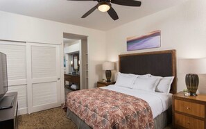 A hotel room with a bed, bedside tables, a ceiling fan, a desk, and a wardrobe. - Hilton Grand Vacation Bay Club-Waikoloa - VILLA - XMAS - Dec 19 to Dec 26 2026 (Waikoloa Village)