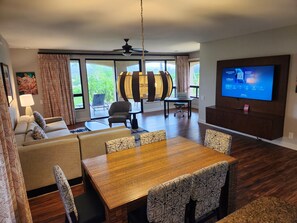 A hotel room with a dining area, a TV, and a view of the outdoors. - Hilton Grand Vacation Bay Club-Waikoloa - VILLA - XMAS - Dec 19 to Dec 26 2026 (Waikoloa Village)
