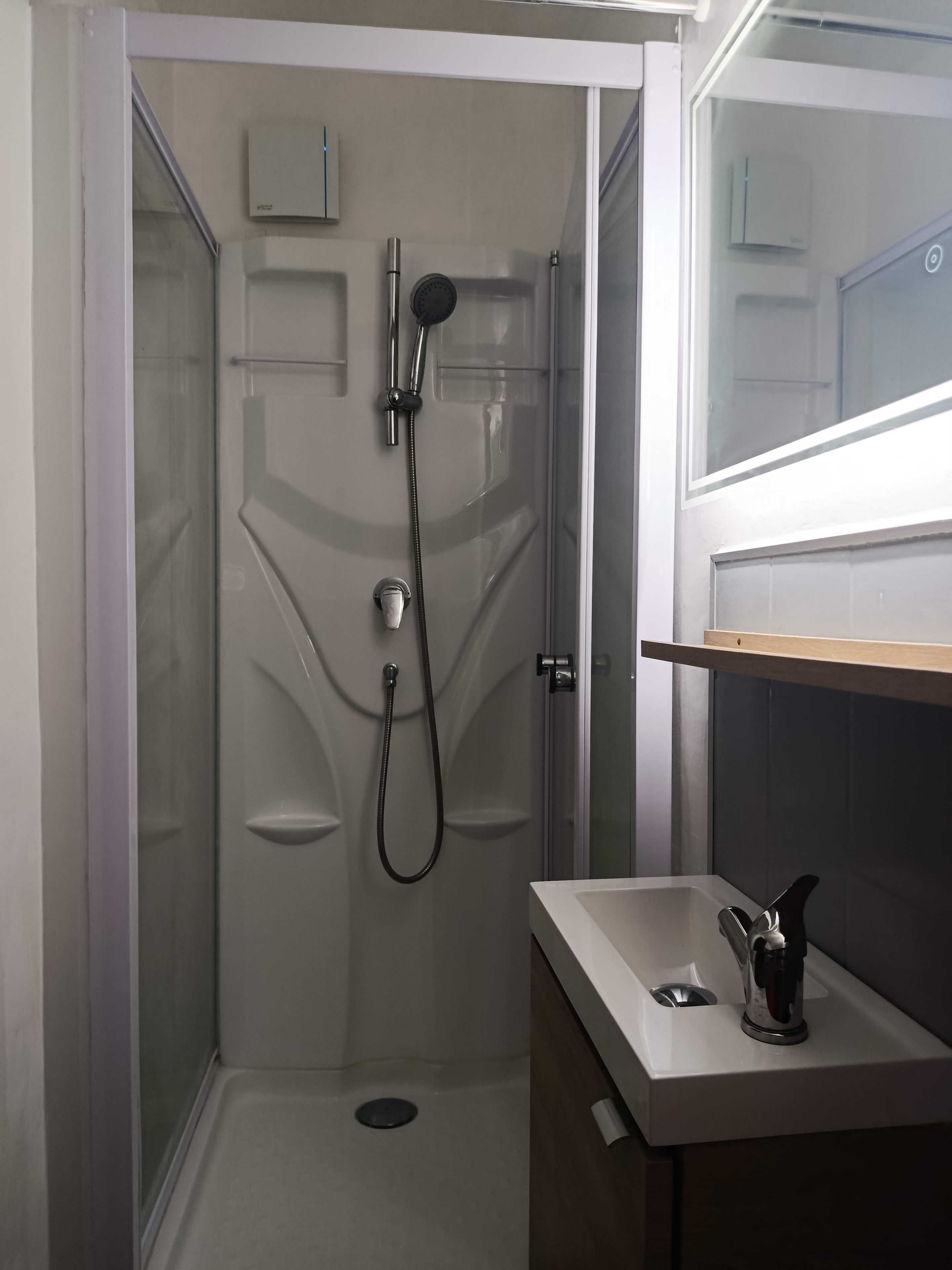 A bathroom with a shower, a sink, and a mirror.