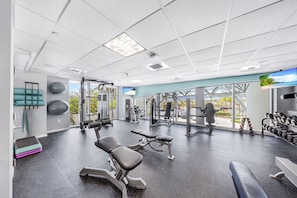 Un gimnasio con equipo de ejercicio, cinta de correr y un ventanal con vistas.