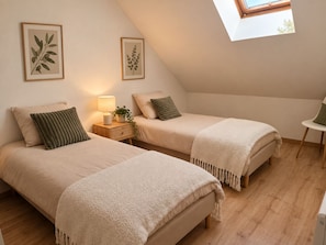 A bedroom with two beds, a bedside table with a lamp, framed botanical prints on the wall, and a skylight. - New Listing (Blangy-sur-Bresle)