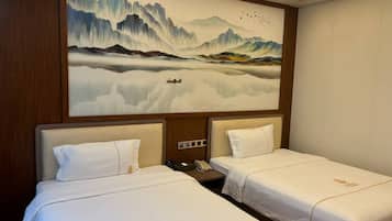 A hotel room with two beds, a large wall mural, and a wooden headboard.