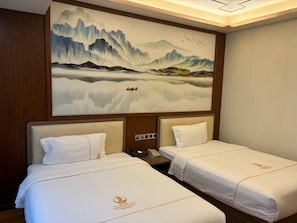 A hotel room with two beds, a large wall mural, and a wooden headboard. - Haizhigang Hotel (Sihanoukville)