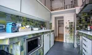 A modern kitchen with a glass backsplash, stainless steel appliances, and a mezzanine level. - TIMELESS ROME APARTMENT WITH PARQUET FLOORS AND A FULLY EQUIPPED KITCHEN (Roma)