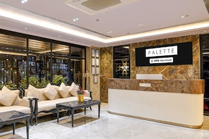 A reception area with a sofa, a coffee table, and a reception desk labeled 'PALETTE.' - Classic Palette Alamin International (Kolkata)