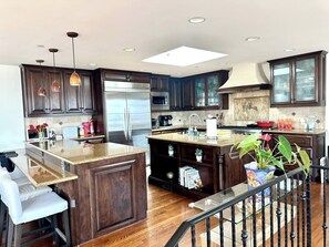 Una cocina moderna con armarios de madera oscura, electrodomésticos de acero inoxidable y una isla central.