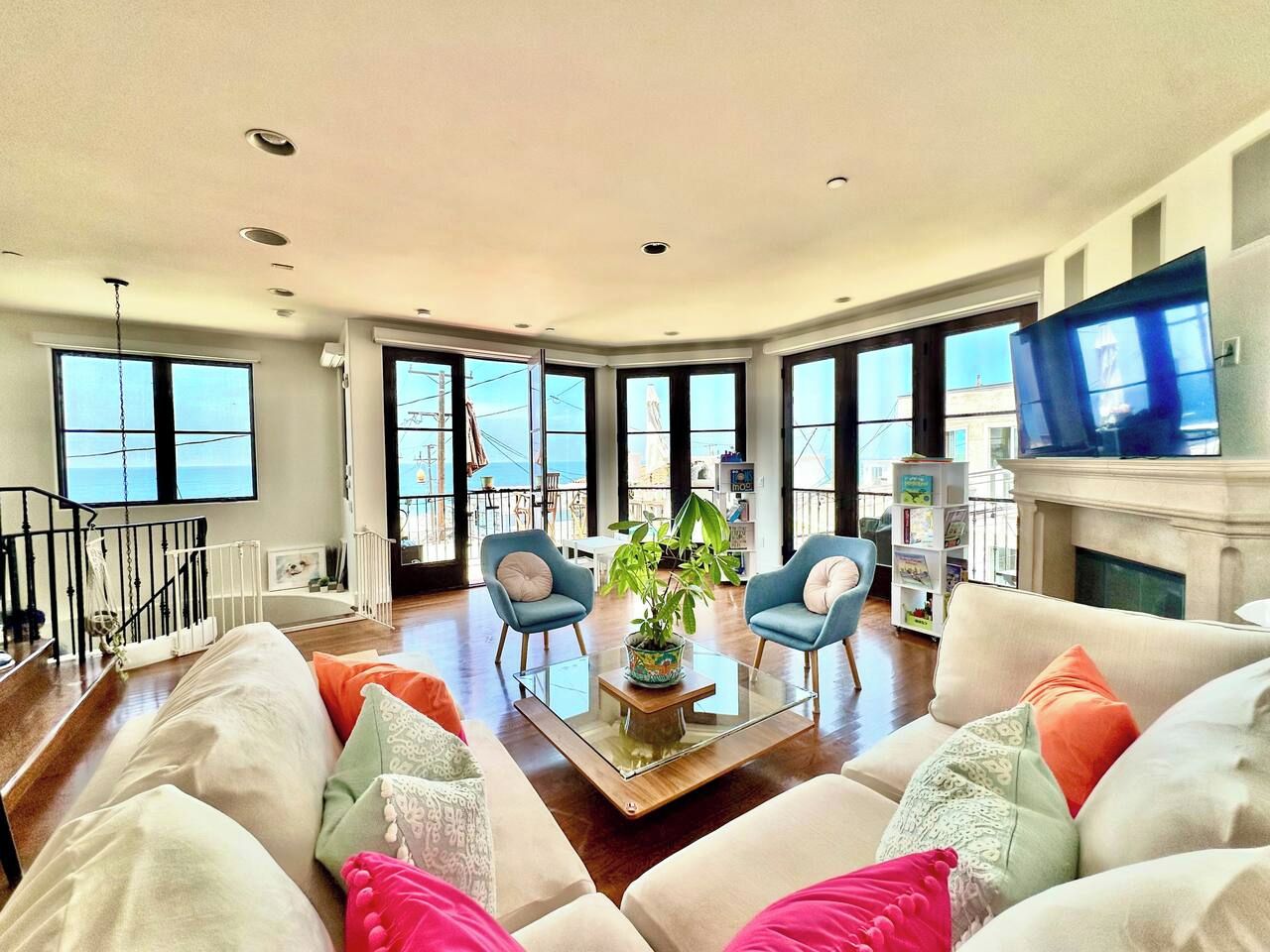 A spacious living room with a large window, a fireplace, and a television.