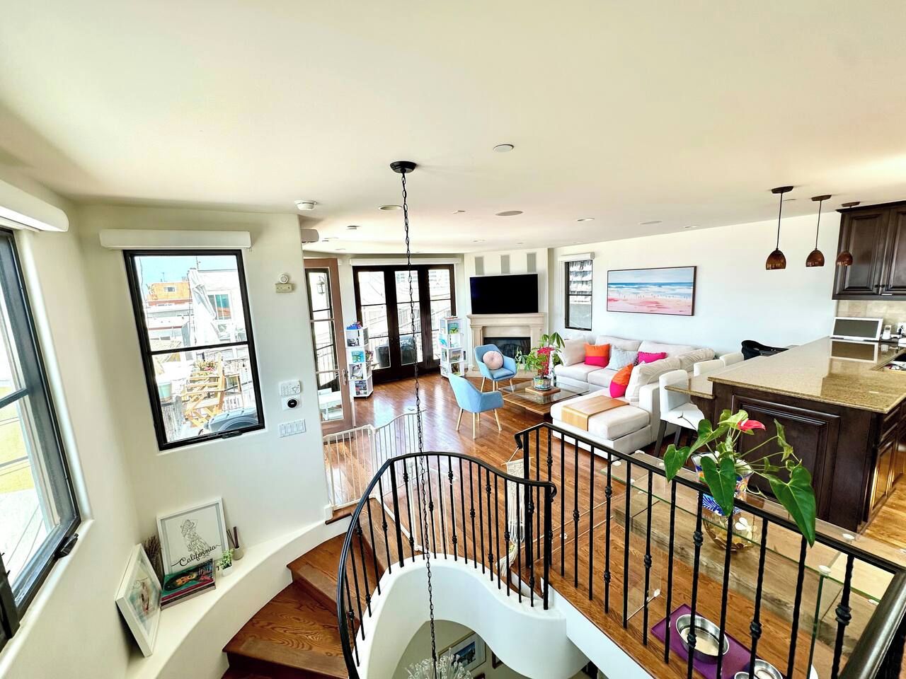 A spacious living area with a staircase, a fireplace, and a kitchen area with a dining table.