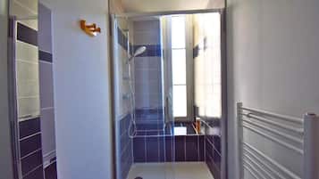 A modern bathroom with a glass-enclosed shower, a towel rack, and a toilet.