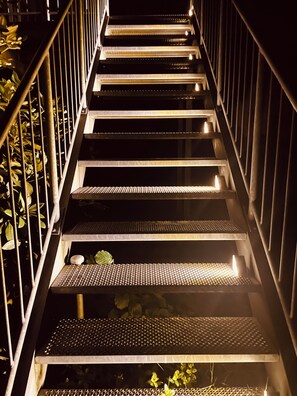 A staircase with metal railings and steps, surrounded by foliage. - New Listing (Kürten)