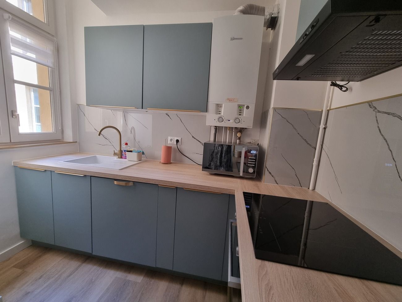 Eine moderne Küche mit eingebautem Geschirrspüler, Mikrowelle und Durchlauferhitzer.