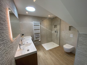Une salle de bain moderne avec un meuble-lavabo, une douche et des toilettes.