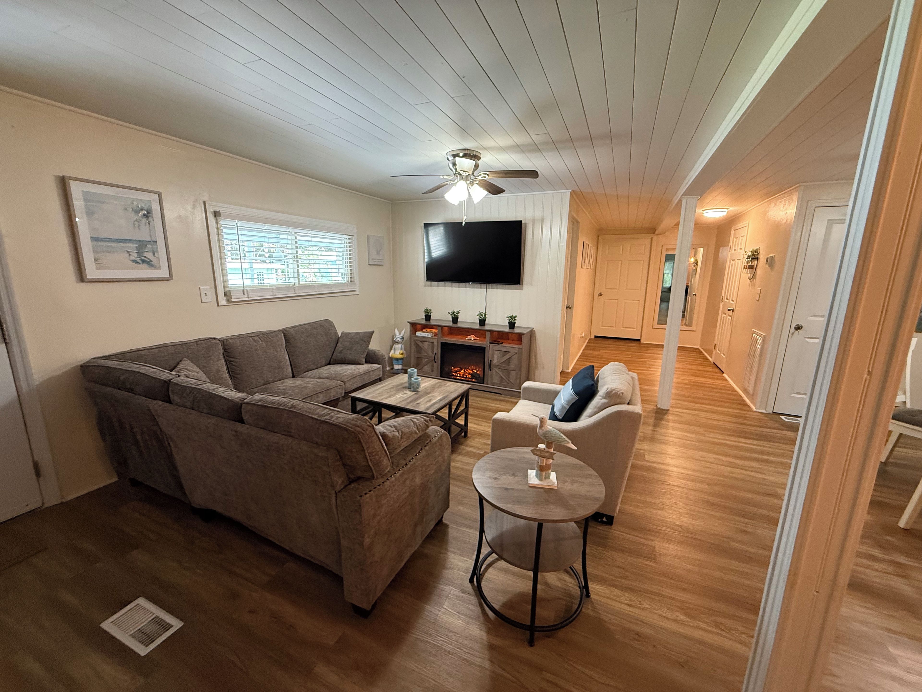 A living room with a sectional sofa, a round coffee table, and a fireplace.