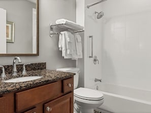 A bathroom with a granite countertop sink, a toilet, a bathtub, and a towel rack. - La Belle Maison  2-Bedroom Lockoff  Just Steps from the French Quarter (New Orleans)