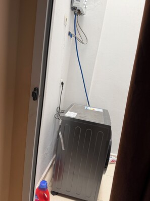 A room with a radiator, a power outlet, and a blue cable connected to a device on the wall.