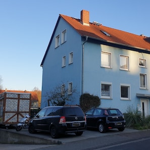 Een gebouw met twee verdiepingen, een rode pannendak en meerdere ramen.