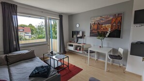 Een moderne hotelkamer met een bed, een bureau, een stoel, een televisie en een schilderij aan de muur.