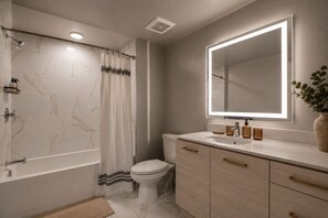 A modern bathroom with a shower, toilet, vanity, and a large mirror. - Ocean-View Penthouse near Beach w/ Rooftop Deck & Pool (Santa Monica)