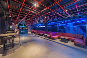 A modern lounge area with seating and a bar. - Suites5 Hotel Bali (KUTA SELATAN)