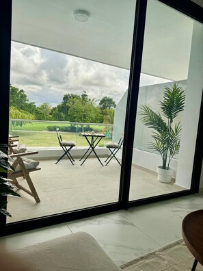 A modern room with a large sliding glass door leading to an outdoor patio area. - Paradise in Punta Cana (Higuey)