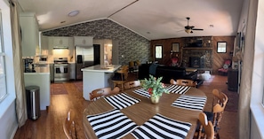 Un espacio habitable amplio con una mesa de comedor, sillas de madera y una chimenea.