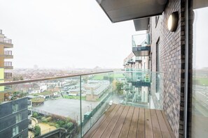 Un edificio moderno con balcón de cristal y vistas a la ciudad.