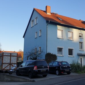 Een gebouw met twee verdiepingen, een rode pannendak en meerdere ramen.