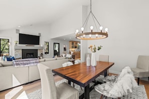 A modern living room with a wooden dining table, a large sofa, and a fireplace. - West Vail Modern (Vail)
