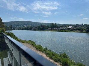 A river with a bridge, houses, and a church on the opposite bank. - New Listing (Profondeville)