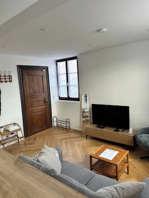 A modern living room with a sofa, a coffee table, a TV, and a window with curtains. - New Listing (Bouxwiller)