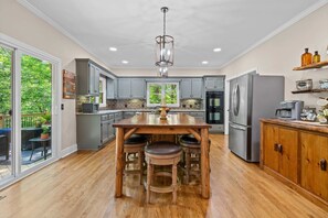 A modern kitchen with a central island, stainless steel appliances, and a view to the outdoors.