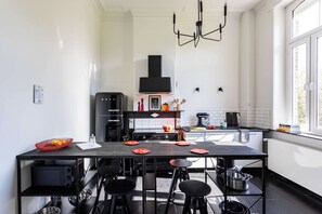 Una cocina moderna con una isla central, electrodomésticos negros y un ventanal que proporciona luz natural.