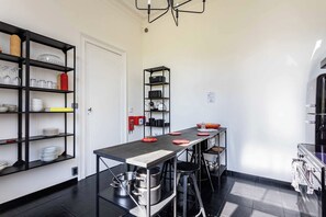 Una cocina moderna con estanterías negras, una isla central y una cafetera.