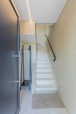 Eine Treppe mit weißen Stufen und Geländer, die zu einer oberen Etage führt.