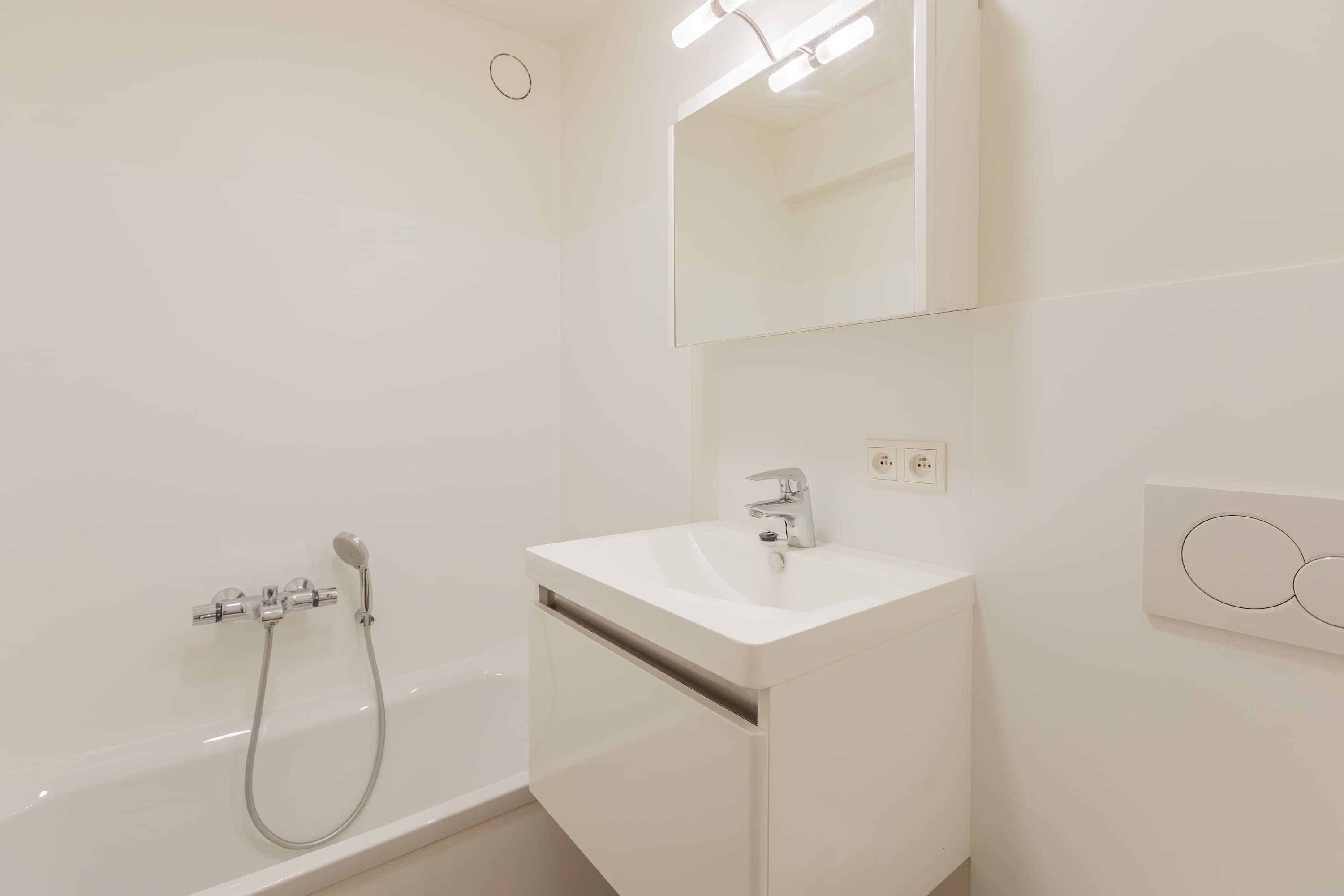Une salle de bain moderne avec une baignoire, un lavabo et un miroir.