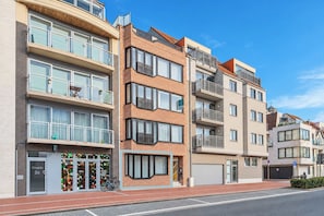 A multi-story residential building with balconies, large windows, and a ground-level entrance. - La Mer Moiselle · 2 bedrooms & private parking (Knokke-Heist)