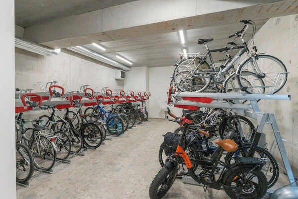 Un espace de stockage pour vélos contenant plusieurs bicyclettes et une moto.
