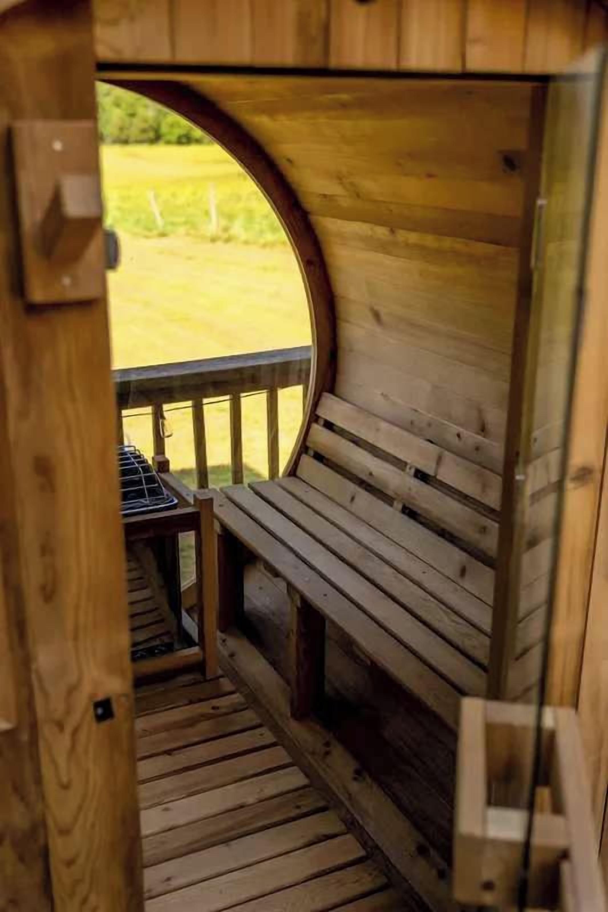 Un banc en bois sur une terrasse, avec une ouverture circulaire donnant accès à un espace extérieur.