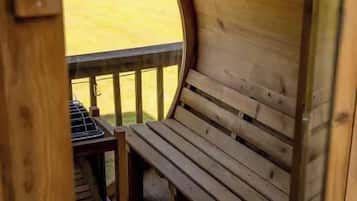 Un banc en bois sur une terrasse, avec une ouverture circulaire donnant accès à un espace extérieur.
