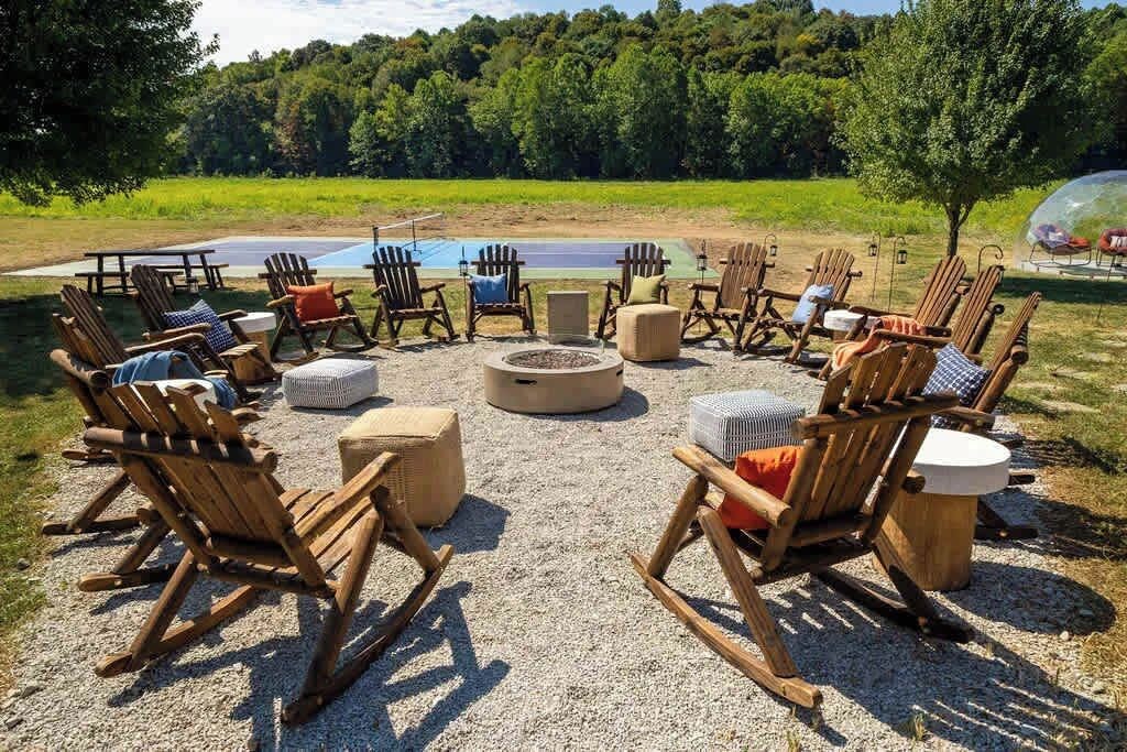 An outdoor seating area with wooden chairs and a fire pit.
