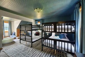 A room with bunk beds, a bathtub, and a ceiling light fixture.