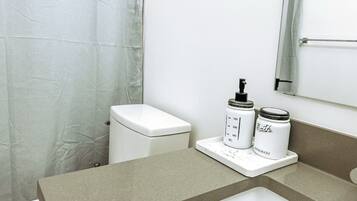A bathroom with a toilet, a sink, and a shower curtain.