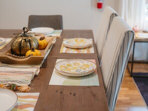 Taula de dinar posta amb plats, una test de llufa i una protecció de taula a ratlles.