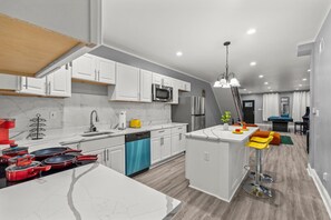 A modern kitchen with white cabinets, a built-in microwave, and a dishwasher. - HYPE BEAST THEMED STR (Philadelphia)