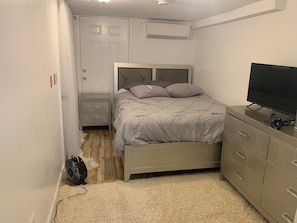 A bedroom with a bed, bedside table, dresser, and a television. - STAR PACIFIC- cozy 1 bedroom brooklyn apartment (Brooklyn)