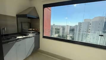 Cocina moderna con un amplio ventanal, estufa y armarios.
